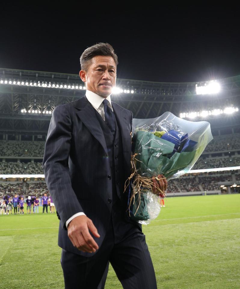 　花束を手にグラウンドを後にする鈴鹿・三浦知良（撮影・金田祐二）