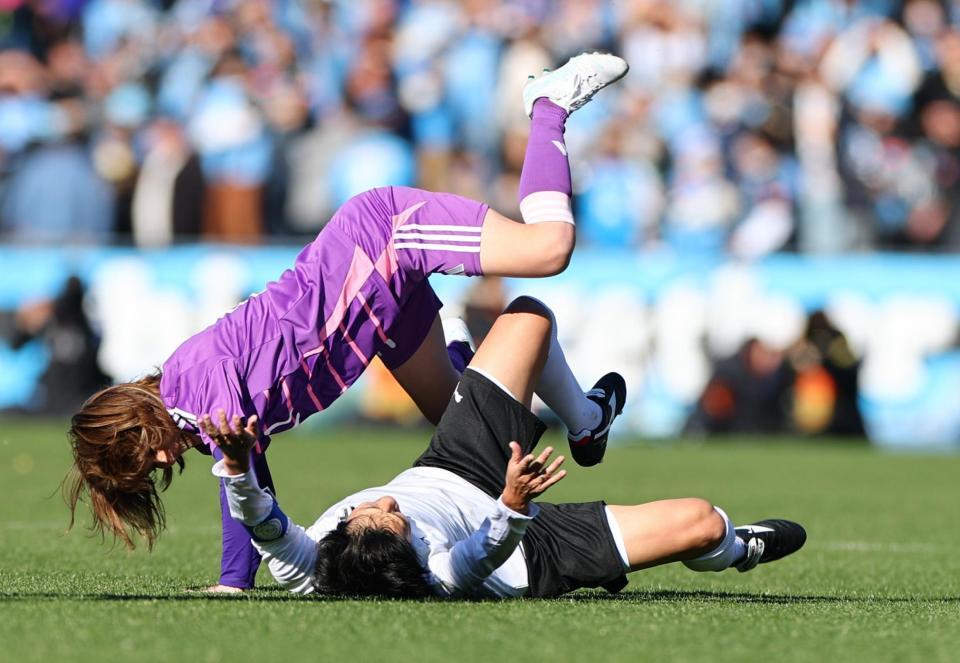 　中村憲剛氏（右）にタックルする吉田沙保里さん