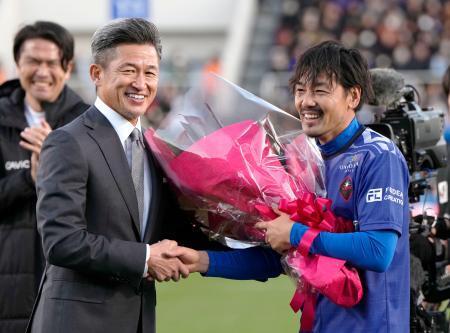 　引退試合を終え、鈴鹿・三浦から花束を贈られる松井大輔さん（右）＝ニッパツ