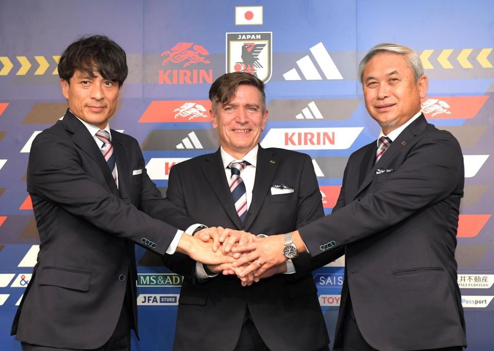 　宮本恒靖日本サッカー協会会長（左）、佐々木則夫日本サッカー協会女子委員長（右）と握手するなでしこジャパン・ニルス・ニールセン新監督（中）＝撮影・佐藤厚