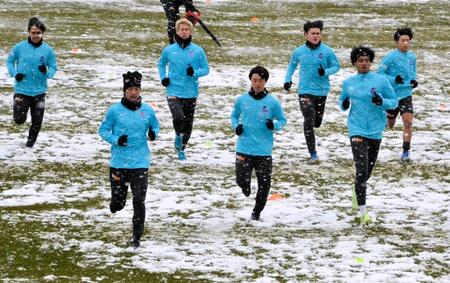 　雪の上をダッシュするジャーメイン良（右から２人目）ら広島イレブン