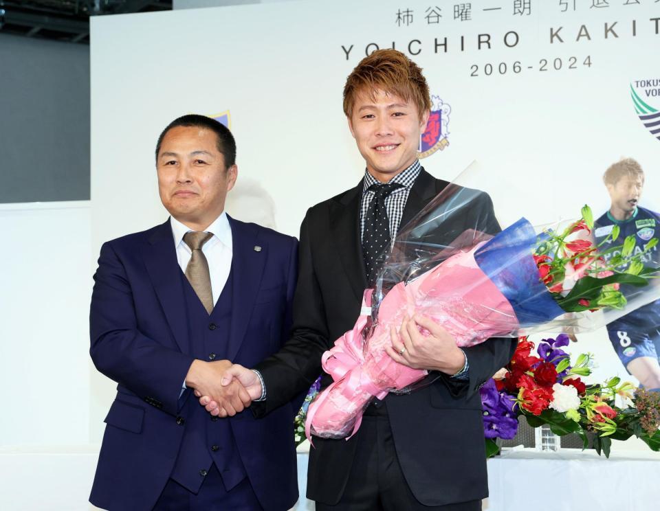 　森島寛晃セレッソ大阪代表取締役社長（左）から花束を手渡され笑顔を見せる柿谷曜一朗（撮影・立川洋一郎）