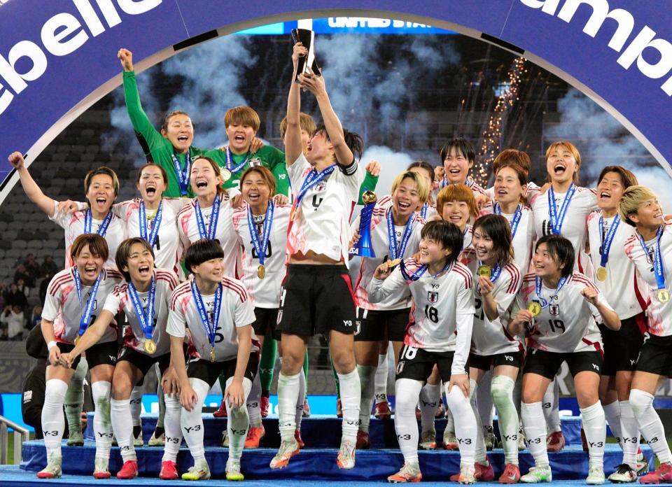 　米国を破り優勝を果たし、トロフィーを掲げ大喜びの熊谷（中央）ら女子日本代表（共同）