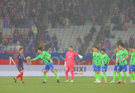 　試合終了時のあいさつに１人だけ遅れてやってきたＦＣ東京・安斎（左）と握手する湘南・鈴木（撮影・吉澤敬太）