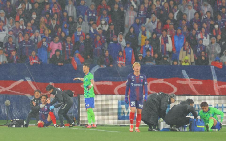 　試合終了直前、ピッチに倒れ込みスタッフに抱えられるＦＣ東京・安斎（左から２人目）＝撮影・吉澤敬太