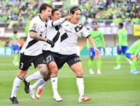 　前半、先制ゴールを決めサポーターを指差して駆け出す神戸・エリキ。左はトゥーレル、右は武藤