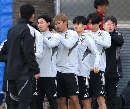 　練習前にトレーニング器具を背中に付ける（左から）南野拓実、守田英正、久保建英、中村敬斗（撮影・堀内翔）