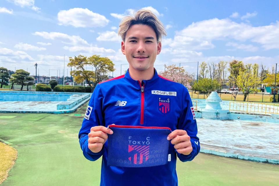 　「オリジナルメッシュポーチ」をアピールするＦＣ東京のＦＷ佐藤恵允　©ＦＣ東京