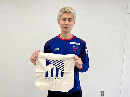 　「東京ガス　Ｄａｙ」特製オーガニックコットンバッグを手にアピールするＦＣ東京のＭＦ橋本拳人　©ＦＣ東京