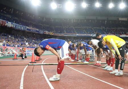 　サポータの前で頭を下げる喜田拓也（左）ら横浜Ｍイレブン（撮影・棚橋慶太）