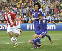 　日本－パラグアイ　前半、ゴール前でクリアする長友（５）。奥は中沢、左はパラグアイのサンタクルス＝プレトリア（共同）