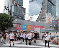 　東京・渋谷のスクランブル交差点を走る本田圭佑。奥はＪＲ渋谷駅（撮影・吉澤敬太）