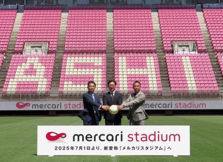 　記念撮影するＪ１鹿島の小泉社長（右）ら＝１９日、カシマスタジアム