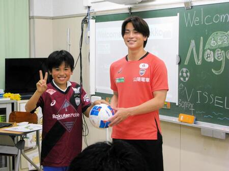 　小学校にサッカーボールを寄贈する永戸勝也（右）