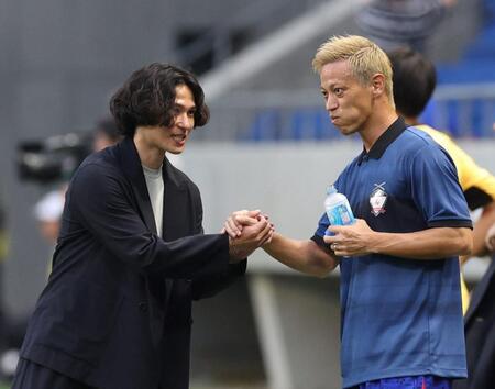 　南野拓実（左）と握手を交わす本田圭佑（撮影・中田匡峻）