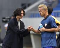 　南野拓実（左）と握手を交わす本田圭佑（撮影・中田匡峻）
