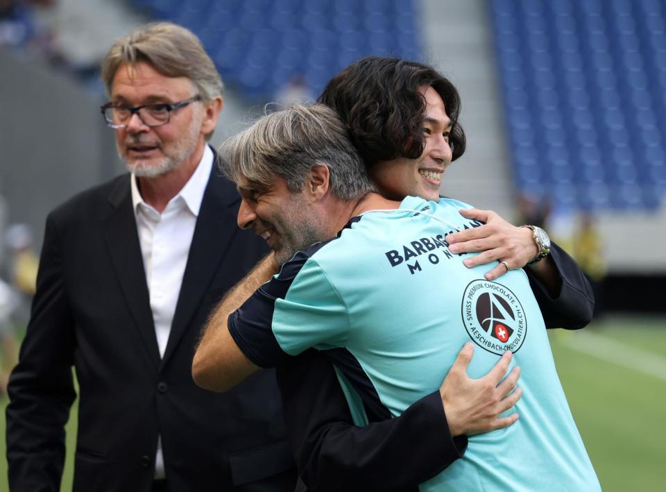 　モナコの関係者とハグを交わす南野拓実。左奥はフィリップ・トルシエ氏（撮影・中田匡峻）