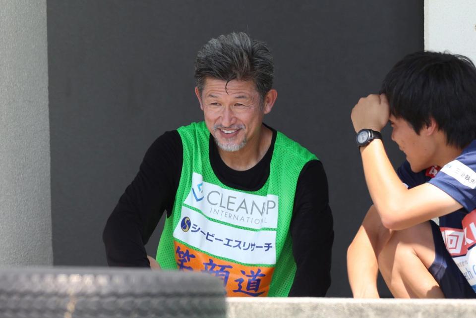 　後半、ベンチ横でストレッチをする鈴鹿・三浦知良（左）＝撮影・中田匡峻