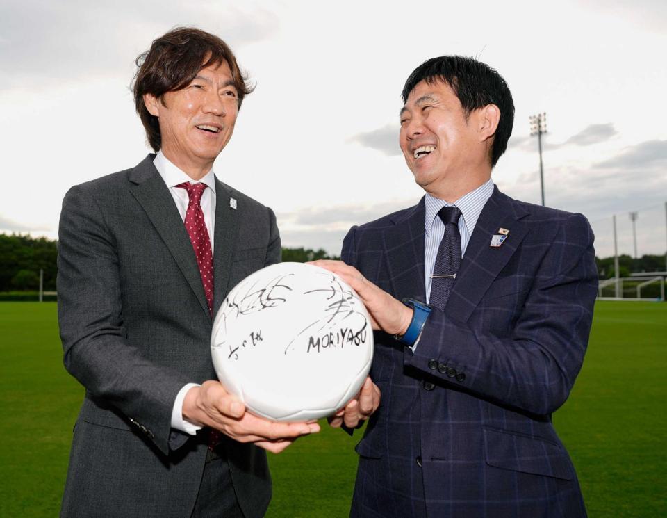 　ボールを手に写真に納まる洪明甫監督（左）と森保一監督