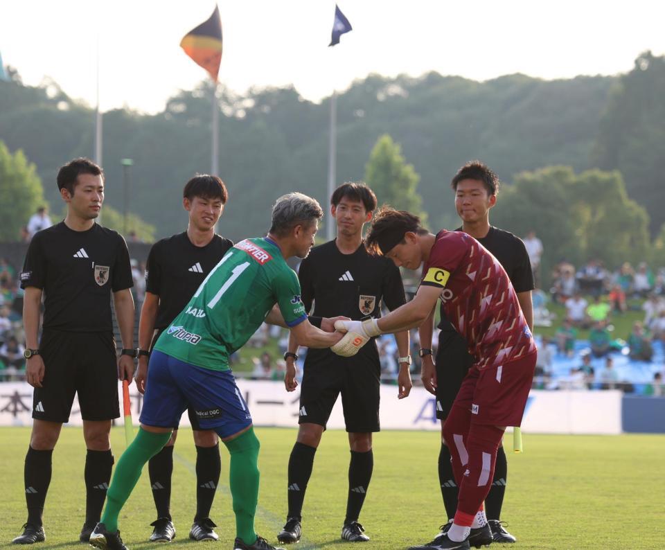 　試合前、握手を交わす鈴鹿・三浦知良（左）＝撮影・中田匡峻