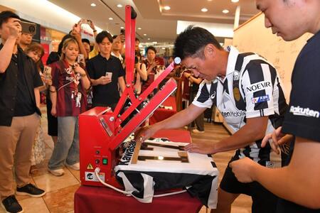 　１日店長として、ユニホームに自ら背番号を圧着させる神戸・吉田孝行監督（撮影・出月俊成）