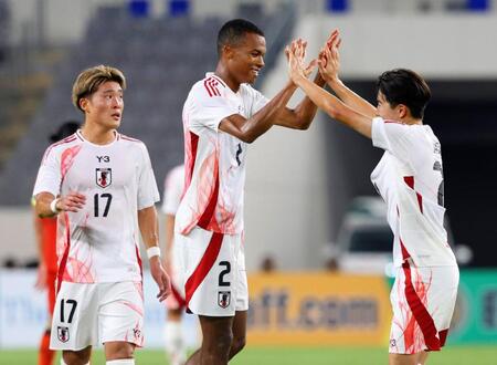 　後半、チーム２点目のゴールを決め、タッチを交わす望月（中央）＝龍仁（共同）