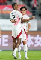 　後半、チーム２点目のゴールを決め、綱島に祝福される望月（左）＝龍仁（共同）