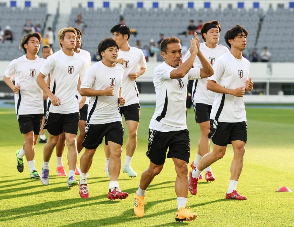 　中国戦を前にウオーミングアップする長友（手前）ら日本代表（共同）