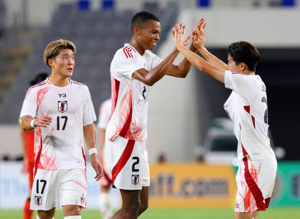 　後半、チーム２点目のゴールを決め、タッチを交わす望月（中央）＝龍仁（共同）