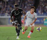 　前半、シュートを放つ横浜Ｍ・ジャンクルード（左）＝撮影・吉澤敬太
