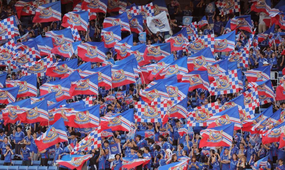 　トリコロールの旗を掲げ応援する横浜Ｍサポーター（撮影・吉澤敬太）