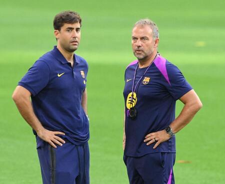 　球団関係者と話をするバルセロナのハンスディーター・フリック監督（右）＝撮影・西田忠信