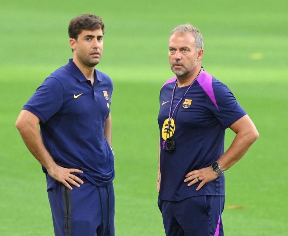 　球団関係者と話をするバルセロナのハンスディーター・フリック監督（右）＝撮影・西田忠信