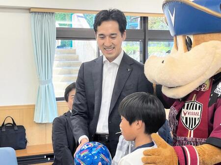 　子どもにサッカーボールを寄贈し、笑顔を見せるＪ１神戸・千布社長