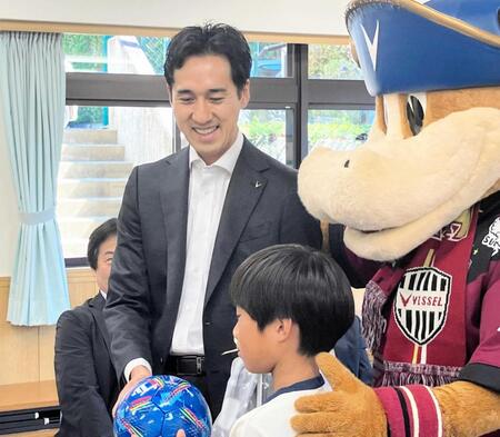 　子どもにサッカーボールを寄贈し、笑顔を見せるＪ１神戸・千布社長