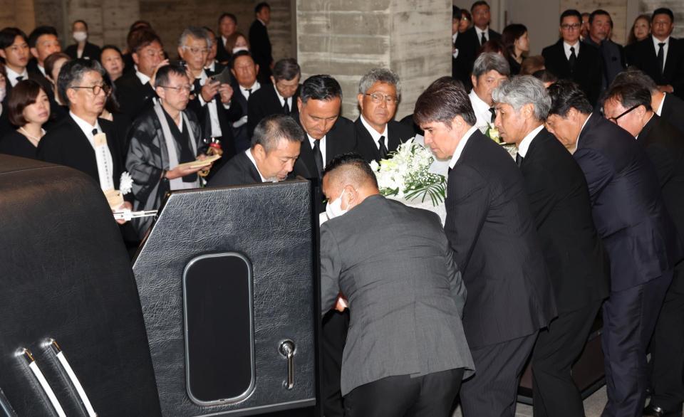 　釜本邦茂さんの柩を霊柩車に入れ込む永島昭浩氏（中央右）＝撮影・中田匡峻