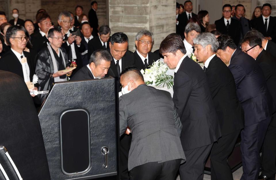 　釜本邦茂さんの柩を霊柩車に入れ込む永島昭浩氏（中央右）