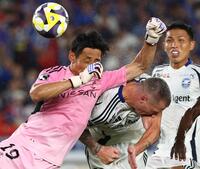 　前半、ゴール前で横浜ＭのＧＫ朴一圭（左）と競り合う町田のミッチェル・デューク