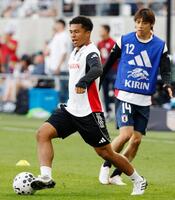 　米国戦を前に、ウオーミングアップする藤田（左）と伊東（共同）