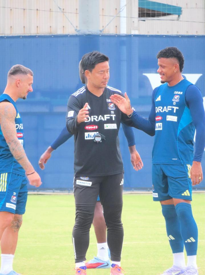 　選手たちと握手をかわす横浜Ｍの大島秀夫監督（中央）