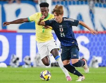 　前半、競り合うブラジルのビニシウス（左）と佐野海