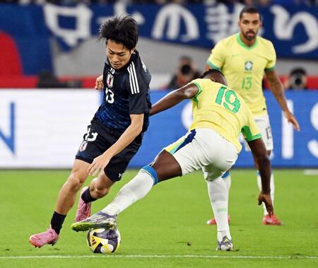 　前半、ブラジル選手と激しく競り合う中村（左）