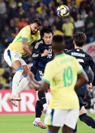 　前半、ブラジル選手と激しく競り合う上田（中央）