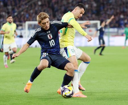 　前半、ブラジル選手と競り合う堂安（左）