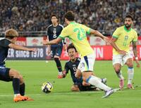 　前半、ブラジル選手と競り合い、声を上げる久保（中央下）