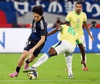 　前半、ブラジル選手と激しく競り合う中村（左）