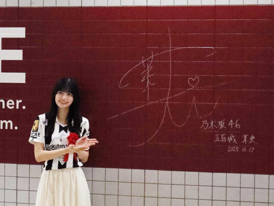 　駅の壁面にサインする五百城茉央（撮影・中野裕美子）