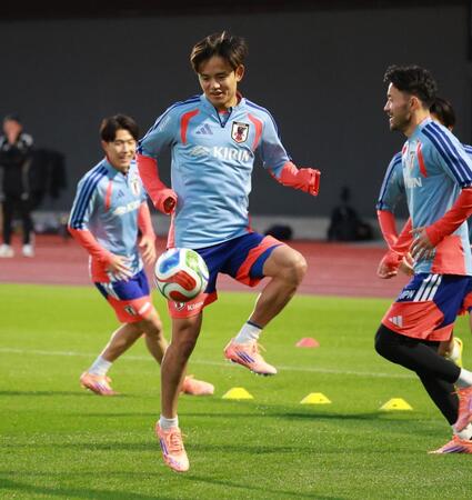 　笑顔で調整する久保建英（撮影・金田祐二）