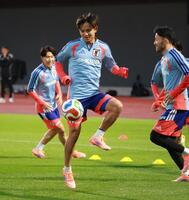 　笑顔で調整する久保建英（撮影・金田祐二）