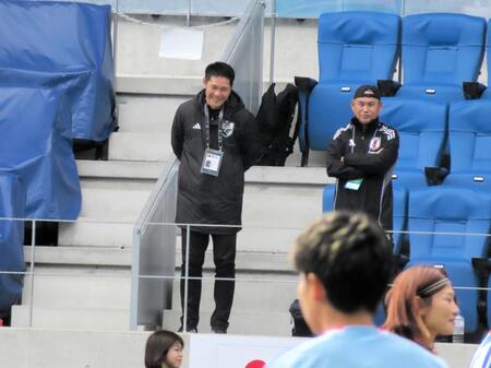 　スタンドから練習を見守る佐々木則夫女子委員長（右）